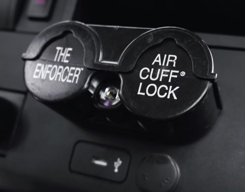 Air cuff lock device labeled 'The Enforcer' on a car dashboard.