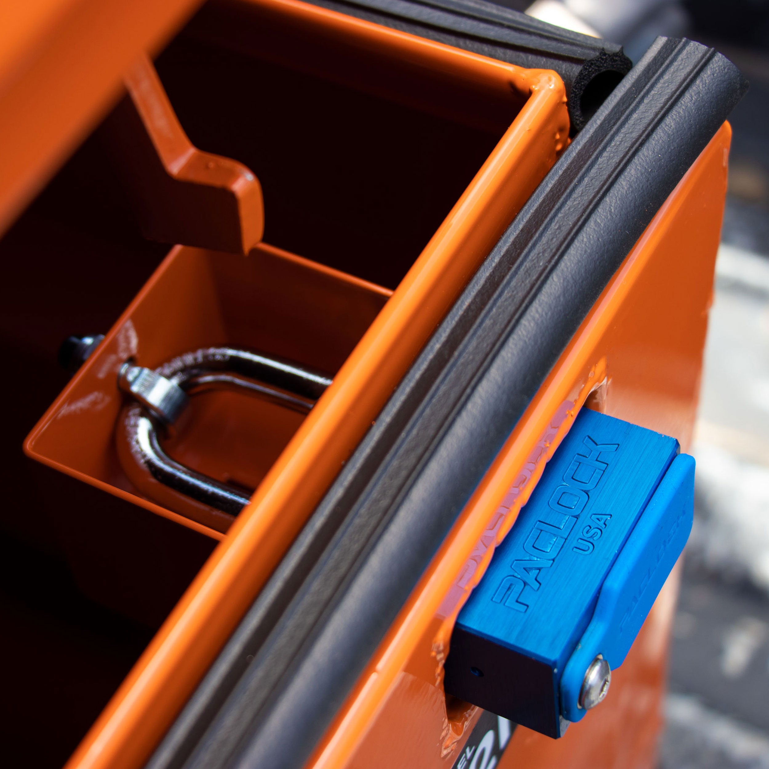 Orange tool box with a blue latch, showing a close-up of the latch mechanism.