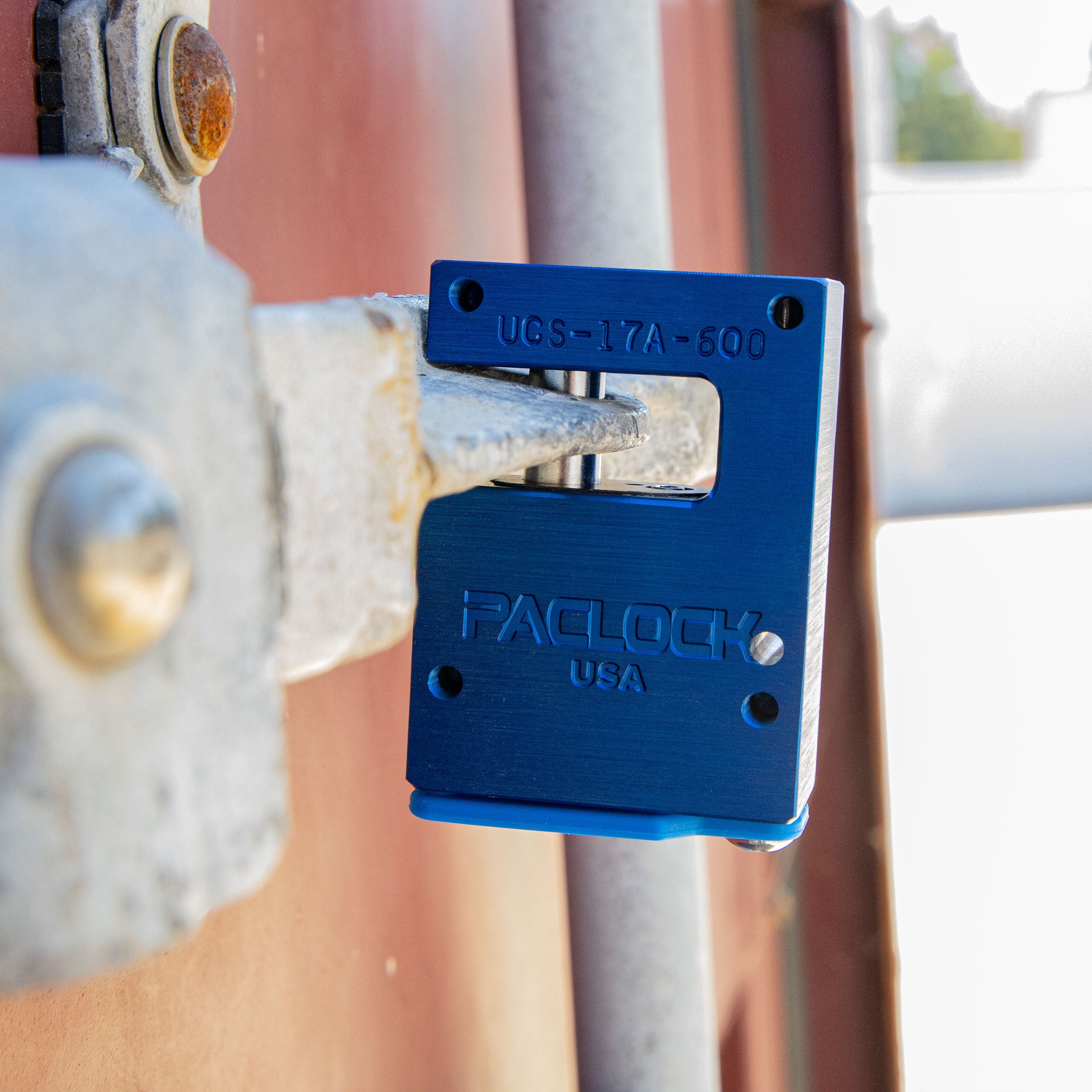 Blue padlock attached to a metal door with blurred background